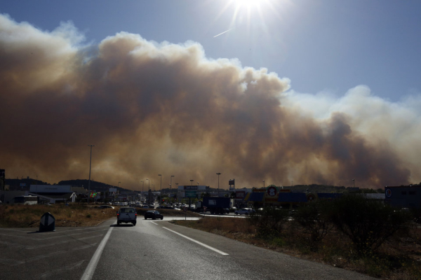 Smoke hangs low as it fills the sky while fires burn north of Marseille